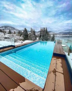 科利比塔Hotel Roser House Boutique - pe malul lacului Colibita的地面上积雪的大型游泳池