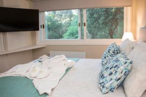 卡内拉Hotel Cozumel Sierra的卧室配有带枕头的床铺和窗户。