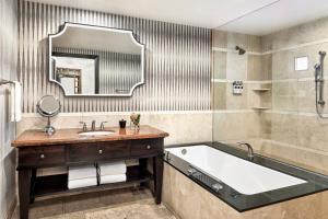 斯科茨蒙特卢西亚奥姆尼斯科茨Spa度假酒店的带浴缸、水槽和镜子的浴室