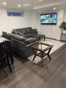 温尼伯Comfortable 3 Bed Basement Unit的客厅配有沙发和桌子