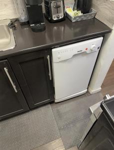 温尼伯Comfortable 3 Bed Basement Unit的厨房配有柜台旁的白色洗碗机