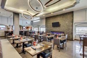 盐湖城盐湖城机场丽笙酒店的餐厅设有桌椅和平面电视。
