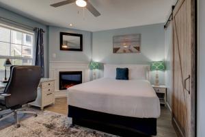 西塞德Inn of the Four Winds Seaside Oceanfront的一间卧室配有一张床、一张桌子和一把椅子