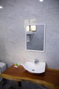 阿鲁沙Greenside Hotel的浴室设有白色水槽和镜子