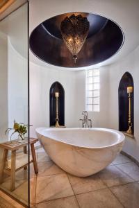 斯科茨蒙特卢西亚奥姆尼斯科茨Spa度假酒店的一个带吊灯的浴室内的一个大型白色浴缸