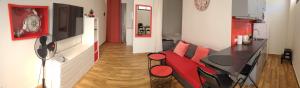 圣地亚哥港La Arena studio的客厅配有红色的沙发和桌子