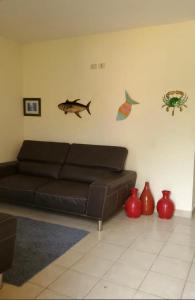 科尔特斯港Casa en la playa puerto cortes的客厅配有棕色的沙发和一些花瓶