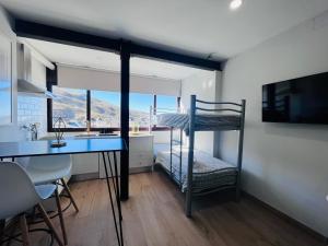 塞拉内华达Apartamentos Sierra Nevada BlueTTravel - Zona baja的客房设有书桌、双层床和厨房。