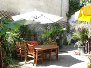 多瑙河畔克雷姆斯奥夫戴尔坤斯特美旅馆的一张木桌和椅子,配有白色遮阳伞