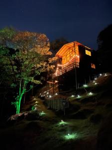 麦德林Bamboo Lodge, vista privilegiada a las montañas的一座在晚上有灯光屋顶的大建筑