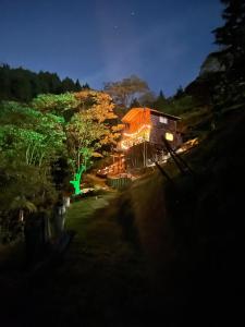 麦德林Bamboo Lodge, vista privilegiada a las montañas的夜晚,房子的一侧有灯