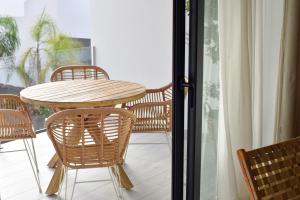 拉奥利瓦Luxury aparment in casilla de costa with Jacuzzi- Follow the sun的阳台上配有一张木桌和椅子,