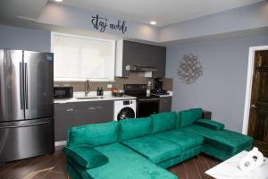 费城Lux Stay by Center City/Temple的客厅设有绿色沙发,厨房设有绿色沙发
