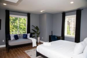 费城Lux Stay by Center City/Temple的一间卧室配有一张床、一张沙发和两个窗户。