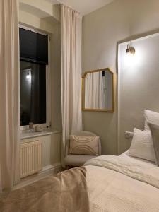 奎德林堡Quedlinburg Marktplatz-Suites的一间卧室设有一张床、一个窗口和一面镜子