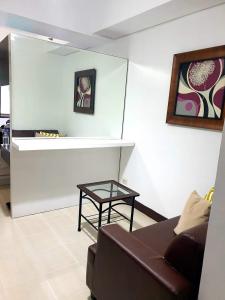 宿务Studio Unit Persimmon Condominium的客厅配有沙发和桌子