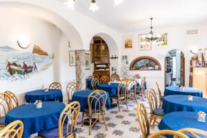 伊斯基亚Hotel Casa Giuseppina的一间配备有蓝色桌椅的用餐室