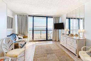 大洋城Golden Sands 605的带沙发和电视的客厅,享有美景。
