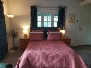 巴林巴林阿普布鲁克维尔乡村民宿的一间卧室配有一张带粉红色棉被的大床
