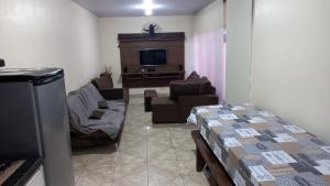 伊瓜苏Casa Rota das 3 Fronteiras的带沙发和电视的客厅