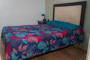 ArandasCasita en Arandas的一间卧室配有一张带五颜六色棉被的床