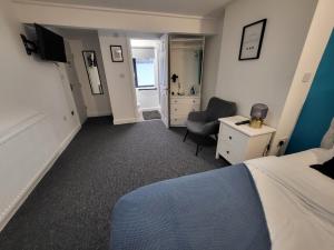 诺丁汉Premier Studios Nottingham - Tring Vale的一间卧室配有一张床、一张桌子和一把椅子
