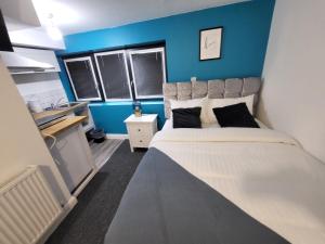 诺丁汉Premier Studios Nottingham - Tring Vale的一间卧室配有一张带蓝色墙壁的大床