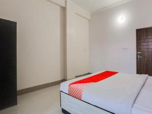 坎普尔OYO Flagship Radhe Radhe Hotels的白色客房,配有一张带红色毯子的床