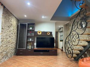 雷东德拉Casa Costeira的一间带电视和石墙的客厅