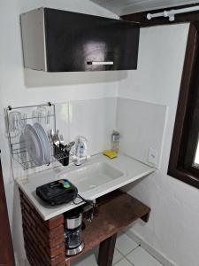佩尼多Chalé do riacho 2的厨房里设有白色水槽,配有微波炉