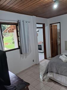 佩尼多Chalé do riacho 2的一间卧室设有一张床、一个窗口和一台电视