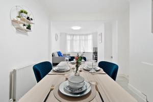 邓斯特布尔Dunstable 3 bedroom house with Free Parking的用餐室配有带蓝色椅子的木桌