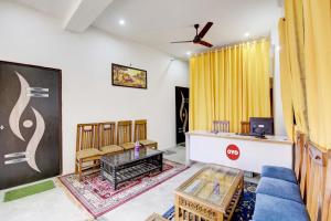 新德里Super OYO Flagship Blossom Inn Burari的客厅配有蓝色的沙发和黄色窗帘