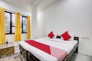 新德里Super OYO Flagship Blossom Inn Burari的一间卧室配有一张带红色枕头的大床