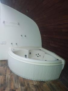 马卡埃Pousada Vale Encantado Macaé的铺有木地板的客房内设有白色浴缸。