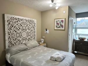 伯恩茅斯Boho Beach House - Beach location的一间卧室配有一张床,上面有两条毛巾