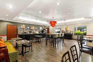 休斯顿加勒里亚贝斯特韦斯特套房酒店的一间带桌椅的餐厅和一间酒吧
