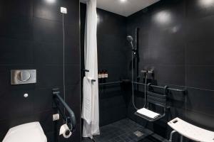路德维希堡路德维希堡NH酒店的黑色浴室设有卫生间和淋浴。