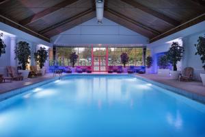 亨廷登Delta Hotels by Marriott Huntingdon的一个带椅子和桌子的大型游泳池