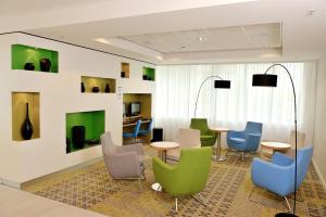 阿姆斯特丹阿姆斯特丹竞技场塔智选假日酒店的一间设有五颜六色的椅子和桌子的等候室