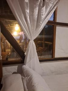 圣维森特Hotel Gabarra Lodge的窗前带窗帘的床