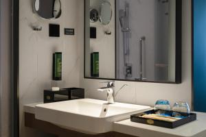 北京北京南站希尔顿欢朋酒店的浴室设有白色水槽和镜子
