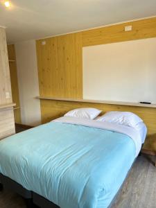 奥尔诺皮伦QUELEN AUSTRAL的一间卧室配有一张大床,配有蓝色的床单和白色的枕头