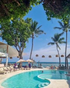 查汶Elephant Beach Club & Resort Samui的棕榈树和海洋海滩上的游泳池
