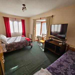 乌斯怀亚Casa de familia的酒店客房设有两张床和一台平面电视。