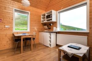 Eskifjörður美吉里度假屋的一间厨房,内设桌子和两个窗户