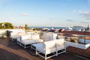 巴拿马城Hotel San Felipe的阳台配有白色椅子,享有海景。