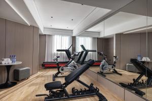 义乌义乌巴里岛雅庭酒店的一间健身房,里面设有跑步机和椭圆机