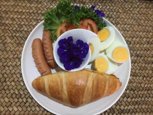 盼武里BC夏日海滩旅馆的包括鸡蛋和三明治的早餐食品