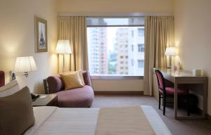 香港恒丰酒店的配有一张床、一张书桌和一扇窗户的酒店客房